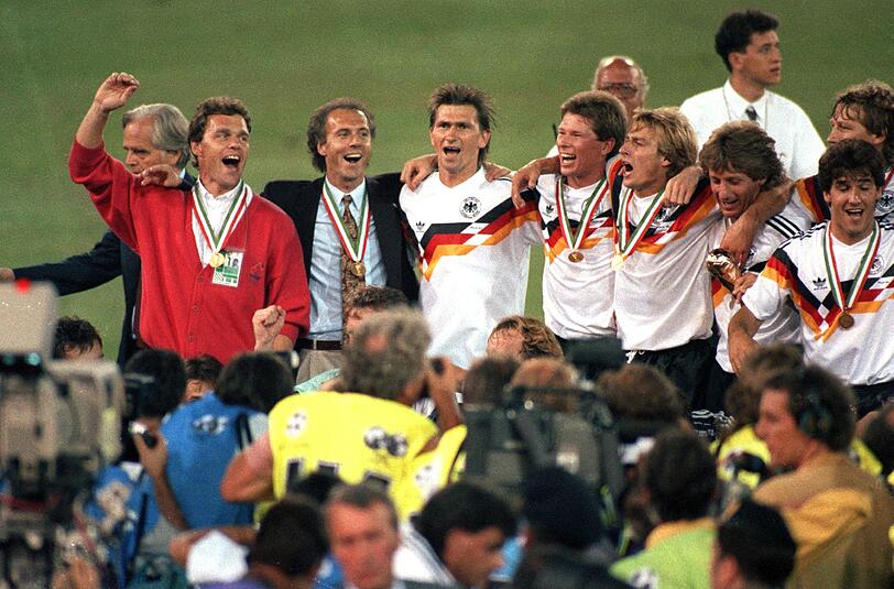 Auf Derwall folgte von 1984 bis 1990 Franz Beckenbauer. 1974 unter Helmut Schön als Mannschaftskapitän selbst Weltmeister geworden, erzielte "der Kaiser" den Titel 1990 auch als Teamchef. Bei der WM 1986 wurde die deutsche Mannschaft unter seiner Führung WM-Zweiter und absolvierte mit ihm insgesamt 66 Länderspiele, von denen sie 34 gewann. Im Bild jubelt Beckenbauer (2.v.l.) mit Holger Osieck, Klaus Augenthaler, Stefan Reuter, Jürgen Klinsmann, Frank Mill und Karl-Heinz Riedle nach dem gewonnenen Endspiel gegen Argentinien in Rom am 8.7.1990.