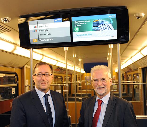 Herbert König (MVG) und Andreas Orth von mc R&D Gmbh vor den Bildschirmen von Fahrgast-TV.