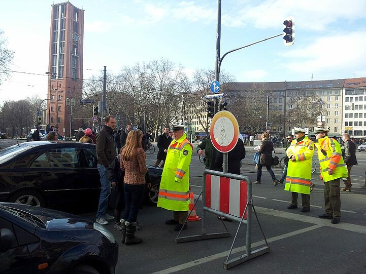 ...und diskutieren mit den Polizisten. Die teilen mit, dass demnächst ein Demonstrationszug vorbeikomme und die Sperrung bis dahin nicht aufgehoben werde. Das kann dauern. Die Menge ist gerade erst am Marienplatz gestartet.