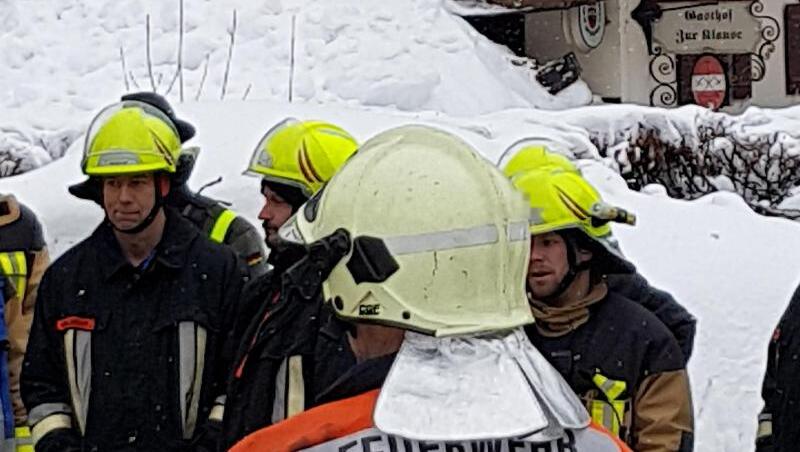Feuerwehrleute stehen an einer Einsatzstelle im Chiemgau, an der das Dach eines Hauses teilweise eingestürzt ist. Foto: Josef Reisner Feuerwehrleute stehen an einer Einsatzstelle im Chiemgau, an der das Dach eines Hauses teilweise eingestürzt ist. Foto: Josef Reisner