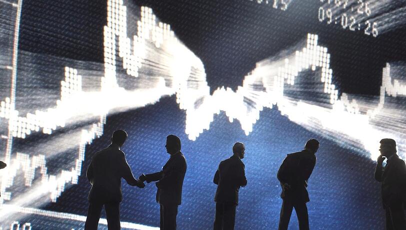 Die Dax-Kurve aus dem Händlersaal der Börse in Frankfurt mit Figuren im Vordergrund. Die Dax-Kurve aus dem Händlersaal der Börse in Frankfurt mit Figuren im Vordergrund.