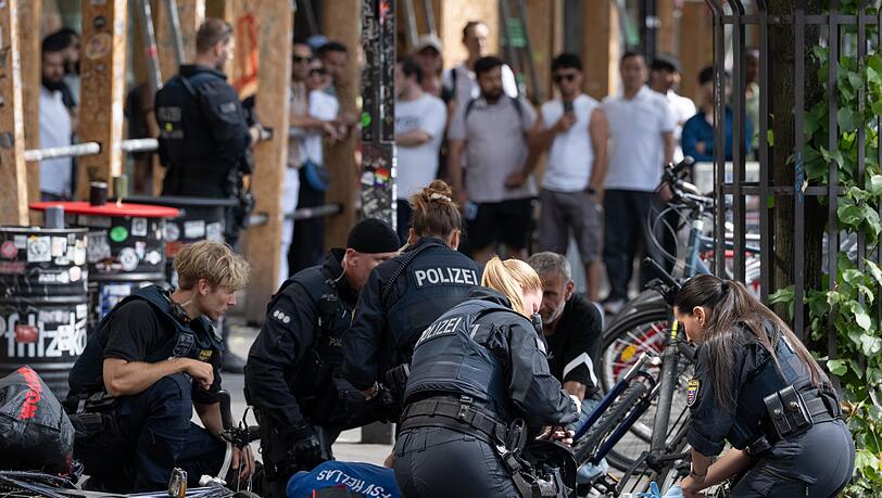 Polizisten knien in der N&auml;he des Frankfurter Hauptbahnhofs am Boden und k&uuml;mmern sich um einen Verletzten.