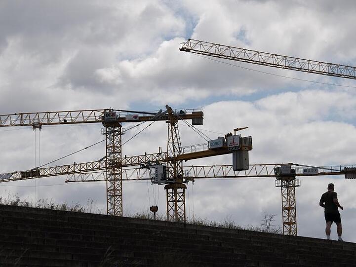 Baukräne stehen auf einer Baustelle. "Die Zeichen stehen eindeutig auf Erholung", teilte das DIW mit.