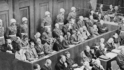 Im Saal 600: 1. Reihe v.l. Hermann Göring, Rudolf Heß, Joachim von Ribbentrop, Wilhelm Keitel, Ernst Kaltenbrunner, Alfred Rosenberg, Hans Frank, Wilhelm Frick, Julius Streicher, Walter Funk, Hjalmar Schacht. 2. Reihe: Karl Dönitz, Erich Raeder, Baldur von Schirach, Fritz Sauckel, Alfred Jodl, Franz von Papen, Arthur Seyß-Inquart, Albert Speer, Konstantin von Neurath, Hans Georg Fritzsche.