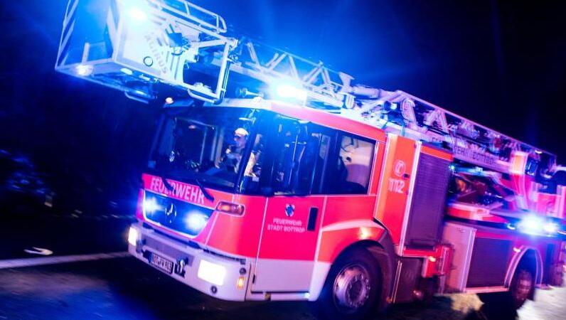 Ein Drehleiterwagen der Feuerwehr fährt mit Blaulicht an einer Unfallstelle vorbei. Foto: Marcel Kusch/dpa Ein Drehleiterwagen der Feuerwehr fährt mit Blaulicht an einer Unfallstelle vorbei. Foto: Marcel Kusch/dpa