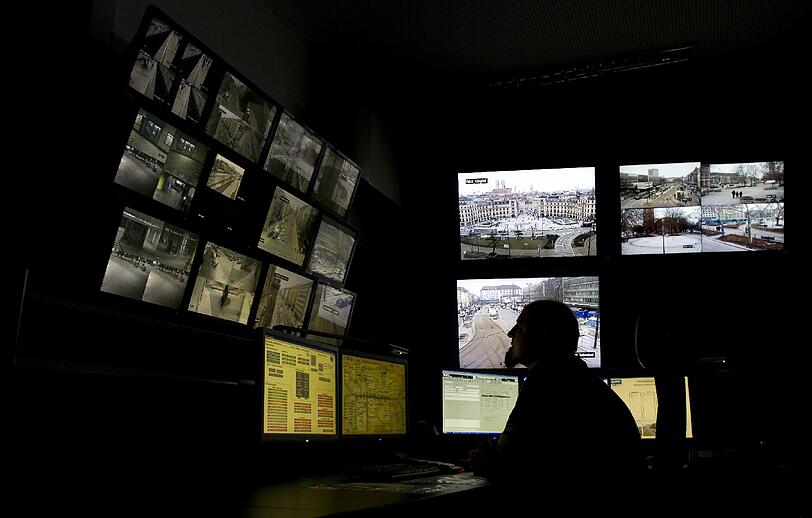 Hat er bald noch mehr im Blick? Ein Beamter sitzt im Polizeipräsidium in der Videoüberwachungszentrale vor mehreren Monitoren.
