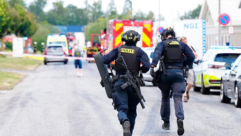 Einsatzkräfte auf dem Weg zum Tatort bei Aalborg. Einsatzkräfte auf dem Weg zum Tatort bei Aalborg.