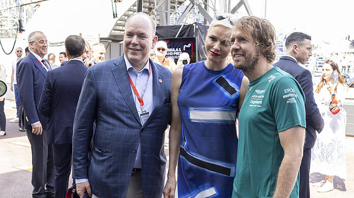 Schlendern durch die Boxengasse und treffen Sebastian Vettel (re.): Fürst Albert und Fürstin Charlene