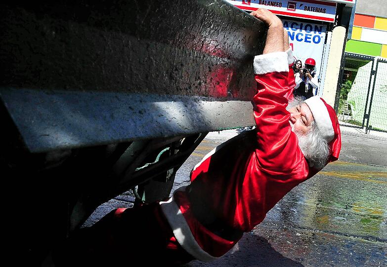 Etwas härtere Gangart: Dieser Nikolaus demonstriert in Santiago de Chile für bessere Bildung - und hängt sich an ein gepanzertes Polizeifahrzeug.