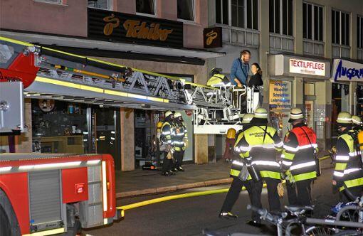 Die Feuerwehr rettet Bewohner mit einem Drehleiterfahrzeug.
