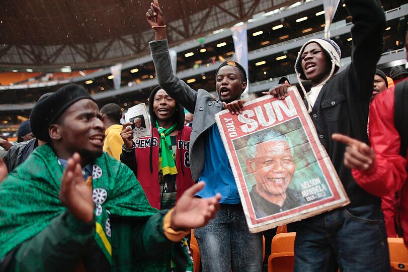 Südafrika verabschiedet sich von Nelson Mandela. Um 14 Uhr MEZ beginnt die gigantische Trauerfeier, die auf 90 Leinwände im Land übertragen wird. So langsam füllen sich die Plätze im Land. Hier die Bilder...