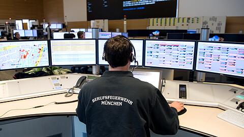 Ein Feuerwehrmann sitzt in der Leitstelle der Berufsfeuerwehr München. (Archivbild)