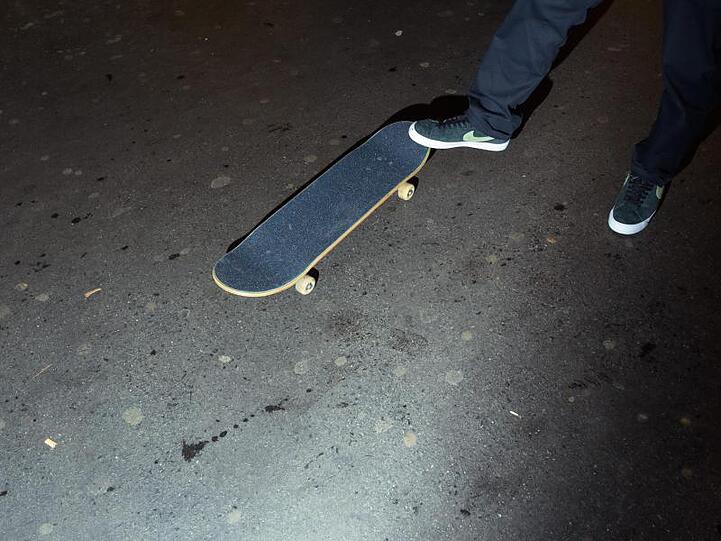 Ein Mann steht mit seinem Fuß auf einem Skateboard. Foto: Gregor Fischer/dpa/Archivbild