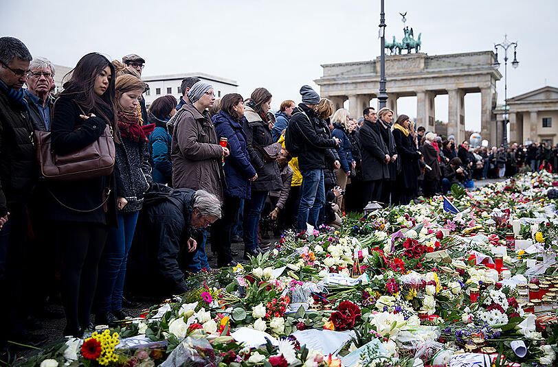 Menschen gedenken der Pariser Terror-Opfer am Brandenburger Tor in Berlin.
