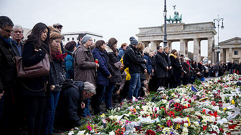 Menschen gedenken der Pariser Terror-Opfer am Brandenburger Tor in Berlin.