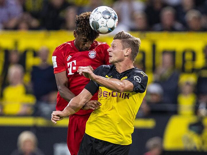 Bayerns Kingsley Coman (l) und Dortmunds Lukasz Piszczek im Kopfballduell.