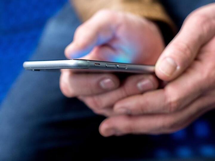 Ein junger Mann benutzt sein Smartphone. Foto: Hauke-Christian Dittrich/dpa/Symbolbild