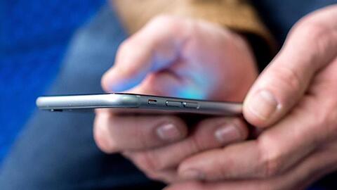 Ein junger Mann benutzt sein Smartphone. Foto: Hauke-Christian Dittrich/dpa/Symbolbild