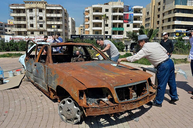 Libanesische Künstler malen auf einem Auto in der Nähe des iranischen Kulturzentrums in Beir Hassan, im südlichen Vorort von Beirut, Libanon.