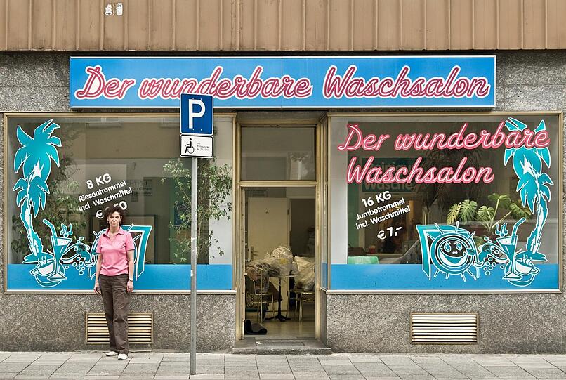 Nicht zu übersehen: der "wunderbare Waschsalon" in der Görresstraße 12 (Maxvorstadt) mit seinem rosa-blauen Schnörkelschild. In den Nullerjahren, als Regine Steckroth (hier im passenden rosa Polo) ihn führt, darf sogar noch geraucht werden. Vorbei. Das Schild hängt heute noch, aber die Klebefolie-Palmen im Fenster hat der neue Betreiber Dieter Lanz abgenommen. Und was die Kundschaft (vom Schlipsträger bis zum Wohnungslosen) liebt: Hier gibt's noch Personal, und man kann sogar bügeln lassen.