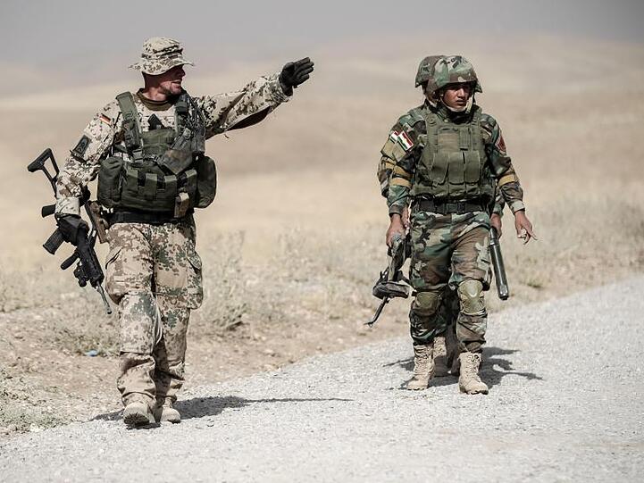 Ein Bundeswehrsoldat und Kämpfer der kurdischen Peshmerga während der Ausbildung nahe Erbil im Norden des Irak.