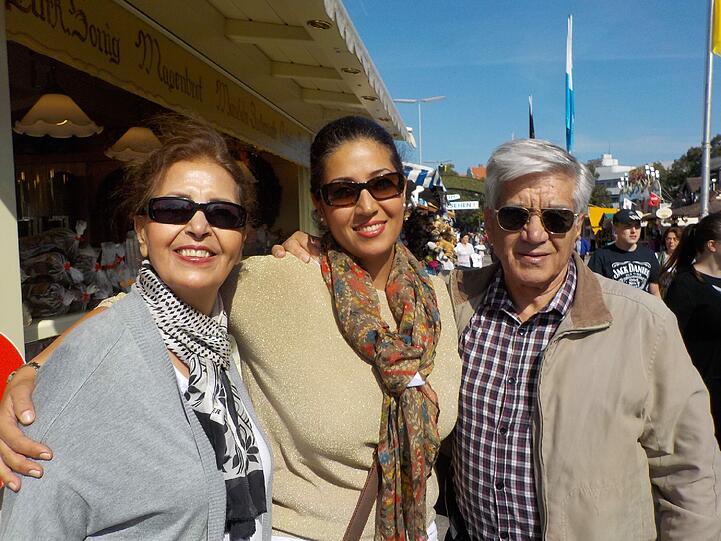 Hama Ganjehisarabi (36) aus Teheran mit Mutter Manijeh (65) und Vater Jannshid (80): &bdquo;Uns fasziniert die starke positive Energie auf dem Oktoberfest. Zu einem perfekten Tag hier gehört für mich als Muslimin ein großes Radler aus alkoholfreiem Bier. Auch meine Eltern aus dem Iran genießen die spezielle Stimmung: Sonne, bunte bayerische Deko, feminine Frauen im Dirndl. Überall wird gelächelt und gelacht.&ldquo;