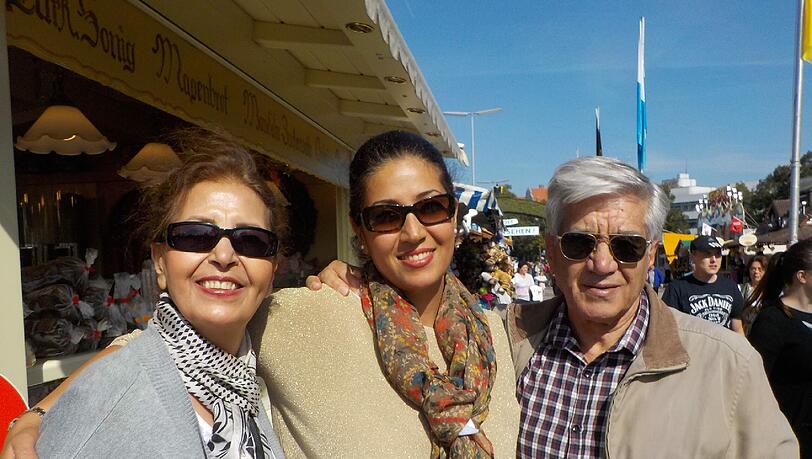 Hama Ganjehisarabi (36) aus Teheran mit Mutter Manijeh (65) und Vater Jannshid (80): &bdquo;Uns fasziniert die starke positive Energie auf dem Oktoberfest. Zu einem perfekten Tag hier gehört für mich als Muslimin ein großes Radler aus alkoholfreiem Bier. Auch meine Eltern aus dem Iran genießen die spezielle Stimmung: Sonne, bunte bayerische Deko, feminine Frauen im Dirndl. Überall wird gelächelt und gelacht.&ldquo;