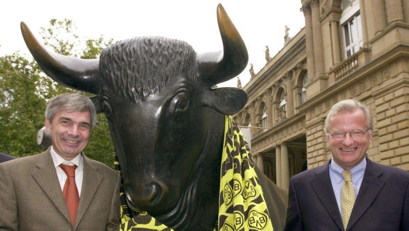 Gerd Niebaum (r), damaliger BVB-Präsident, und der damalige BVB-Manager Michael Meier stehen am 31.10.2000 vor der Frankfurter Börse mit einem übergroßen Fanschal am Bronzebullen.