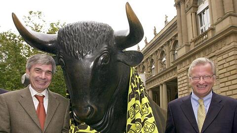 Gerd Niebaum (r), damaliger BVB-Präsident, und der damalige BVB-Manager Michael Meier stehen am 31.10.2000 vor der Frankfurter Börse mit einem übergroßen Fanschal am Bronzebullen.