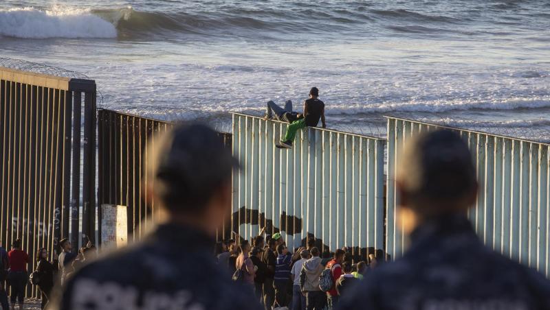 Zwei mexikanische Polizisten beobachten bei Tijuana Migranten am Grenzzaun zu den USA. Zwei mexikanische Polizisten beobachten bei Tijuana Migranten am Grenzzaun zu den USA.