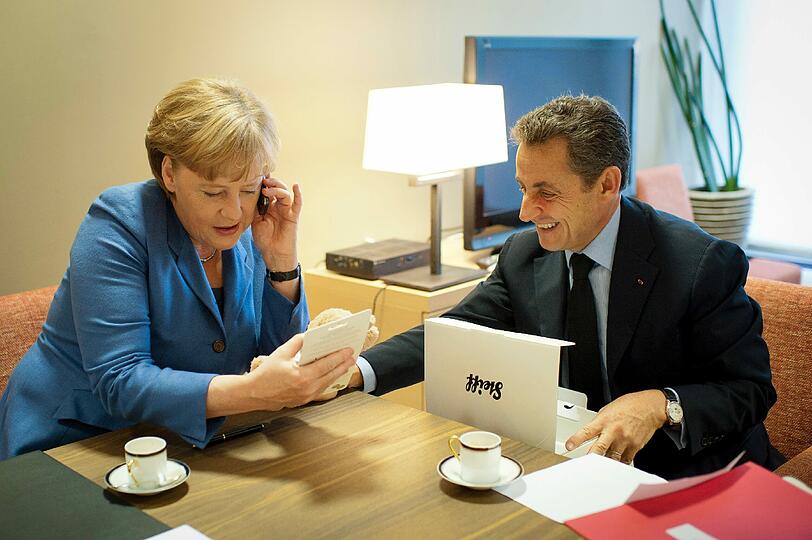 Nicolas Sarkozy kehrt von den harten Verhandlungen in Brüssel nicht mit leeren Händen zurück nach Paris: Bundeskanzlerin Angela Merkel (CDU) überreichte dem französischen Staatschef am Sonntag einen flauschigen hellbraunen Teddy. Der ist natürlich nicht für Sarkozy, sondern für &bdquo;le bébé&ldquo;.