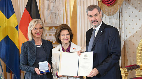 Ministerpr&auml;sident Markus S&ouml;der und Bayerns Sozialministerin Ulrike Scharf (l.) verleihen K&ouml;nigin Silvia von Schweden die Staatsmedaille f&uuml;r soziale Dienste.