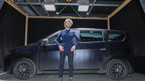 Der Münchner Jona Christians ist einer der Gründer von Sono Motors. Er steht vor dem Sono Sion, einem von ihm und Laurin Hahn erfundenen E-Auto, das an Türen, Motorhaube und Dach Solarpaneele hat, die Strom für wöchentliche 120 Kilometer erzeugen können.