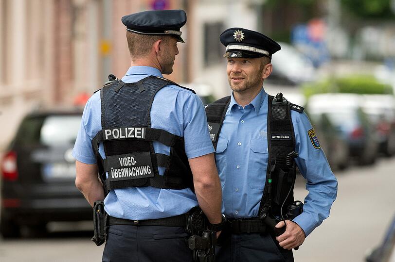 Zwei Polizeibeamten mit mobilen Videokameras.