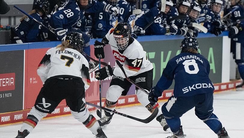 Franziska Feldmeier (l) und Emily Nix (M) von Deutschland und Eve Savander von Finnland kämpfen um den Puck.