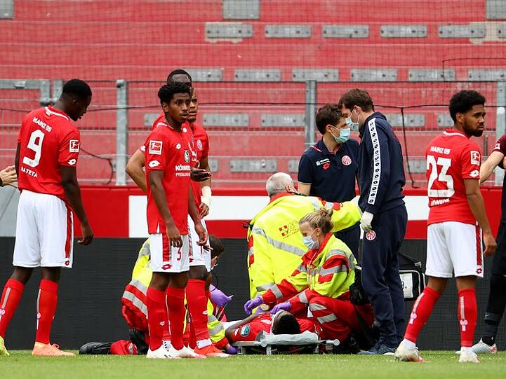 Der Mainzer Taiwo Awoniyi wird verletzt auf einer Trage versorgt. Foto: Kai Pfaffenbach/reuters/Pool/dpa/Archivbild