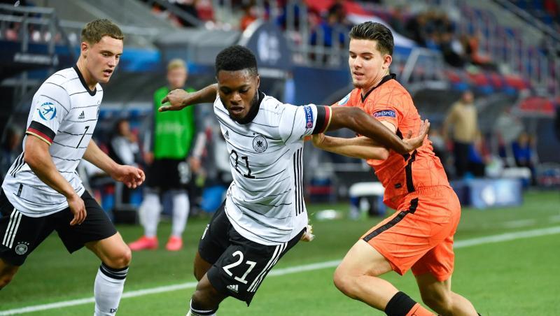 U21-Nationalspieler Ridle Baku (M.) setzt sich im EM-Halbfinale im Zweikampf gegen den Niederländer Ferdi Kadioglu (r) durch.