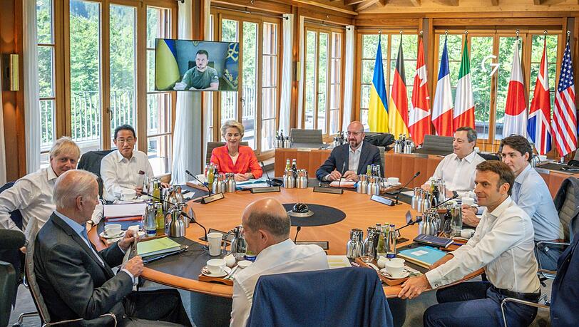 Die Gipfelteilnehmer sitzen bei der Arbeitssitzung zusammen.