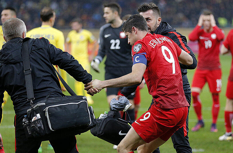 Im WM-Qualispiel gegen Rumänien wurde Polens Kapitän Robert Lewandowski von einem Knallkörper getroffen. Nach kurzer Behandlung spielte der Bayern-Star weiter - und erzielte noch einen Doppelpack. Die Bilder.