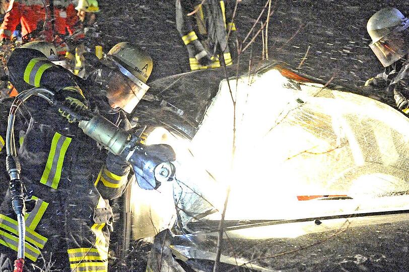 Die Feuerwehr befreit die Verletztem aus dem Wrack. Ein Schweinwerfer spendet Wärme.