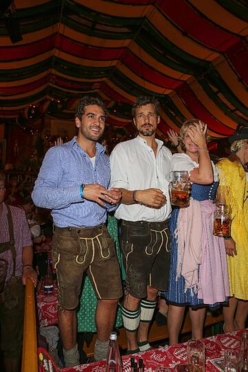 Hier stehen die beiden Schauspieler noch ganz brav mit der Maß auf den Tischen.