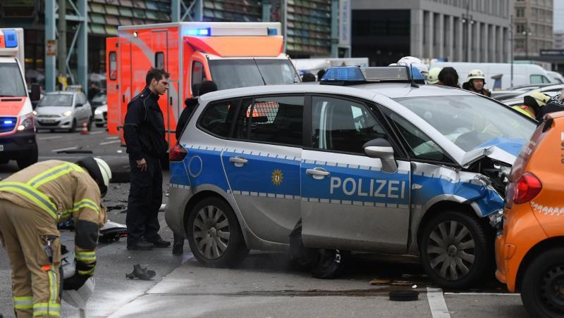 Ein Polizist und Feuerwehrmänner am Unfallort in Berlin. Ein Polizist und Feuerwehrmänner am Unfallort in Berlin.
