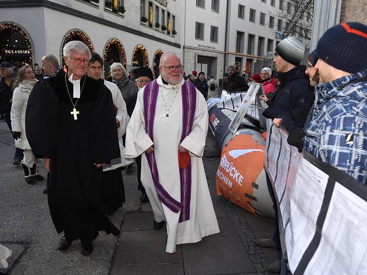 Der Vorsitzende der Deutschen Bischofskonferenz Reinhard Kardinal Marx (M) geht an einer Mahnwache. Foto: Felix Hörhager/dpa/Archivbild