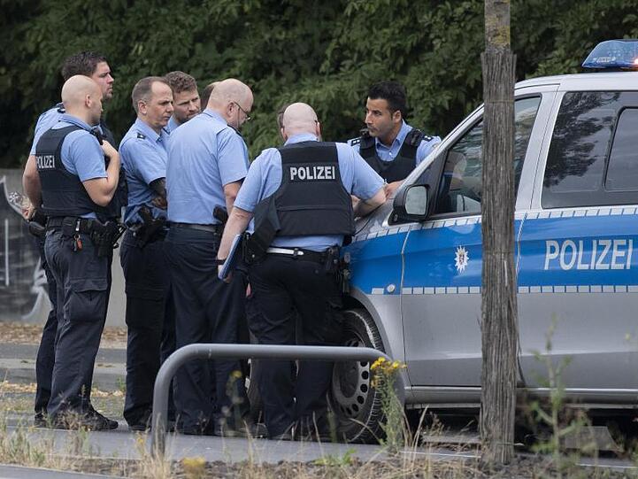 Polizisten bei einer Lagebesprechung in unmittelbarer Nähe des Blindgängers.