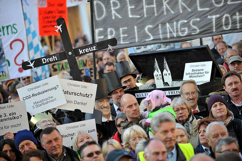 Teilnehmer einer Demonstration gegen den Bau der dritten Startbahn am Münchner Flughafen halten am Samstag auf dem Marienplatz in München Plakate in die Höhe.