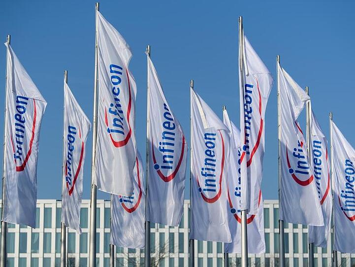 Flaggen mit dem Logo von Infineon flattern im Wind. Foto: Matthias Balk/Archiv