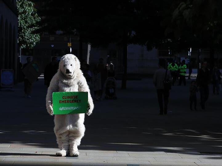Keine gute Zeit für Eisbären: Ein Demonstrant in Manchester ist im Kostüm gekommen.
