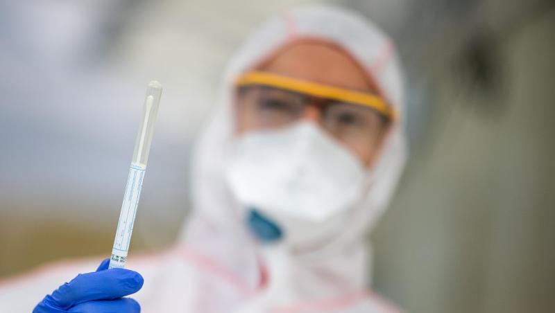 Ein Mitarbeiter hält in einem Abstrichzentrum einen Coronatest-Abstrich in der Hand. Foto: Sebastian Gollnow/dpa/Symbolbild