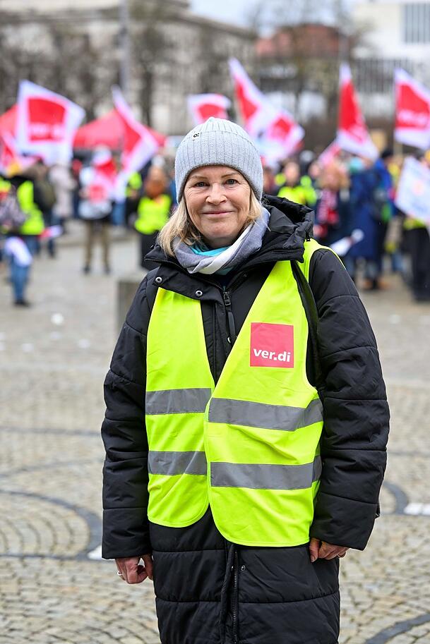 Claudia Weber, die Chefin von Verdi München: Hier steht sie kurz vor der Wahnsinnstat noch in Streiklaune am Königsplatz, im Hintergrund die bereits versammelten Mitarbeiter und Mitarbeiterinnen des öffentlichen Dienstes. Minuten später kam die Nachricht, ein Auto sei in den noch fehlenden Demozug gerast. Weber brach umgehend die Versammlung ab.