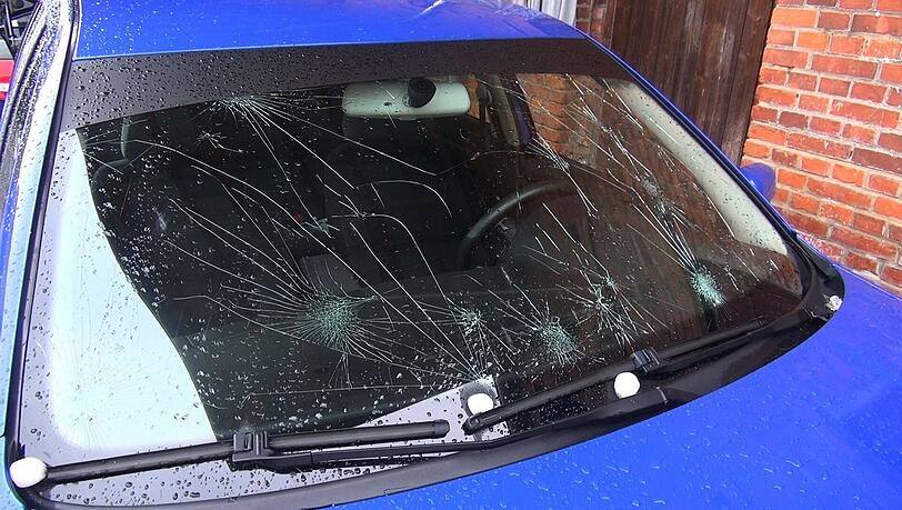 Beschädigt ist die Windschutzscheibe eines Autos nach einem Hagelschauer. Beschädigt ist die Windschutzscheibe eines Autos nach einem Hagelschauer.